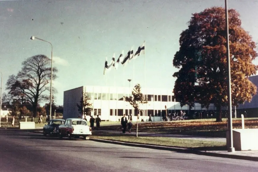 Vanha auto ja liputus ylipiston edustalla.