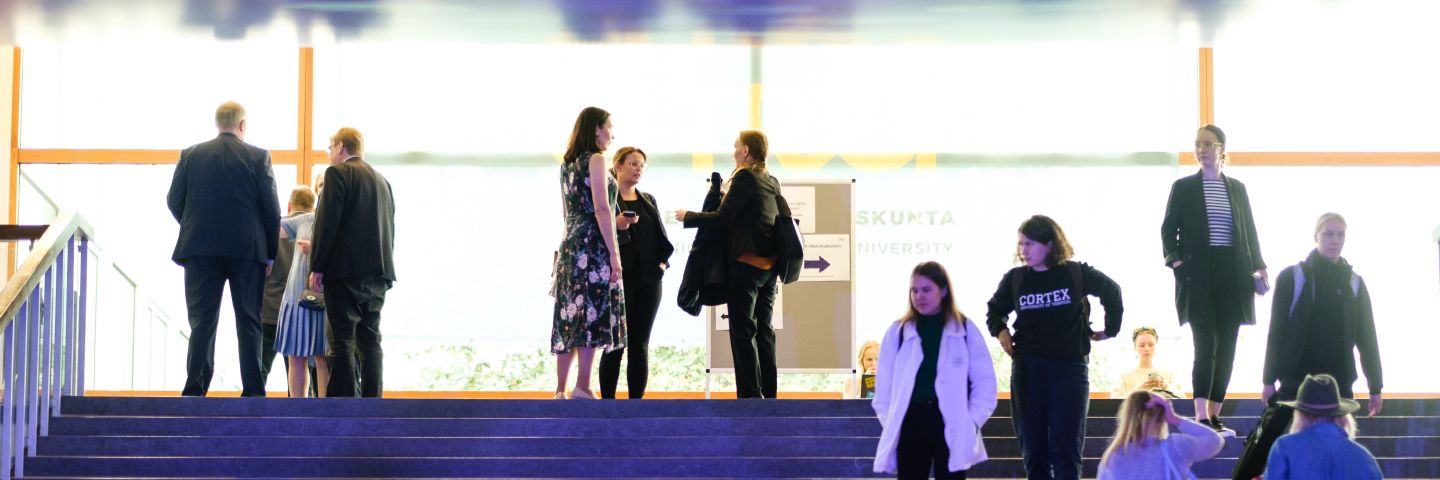 Ihmisiä Tampereen yliopiston Päätalon portaikossa.