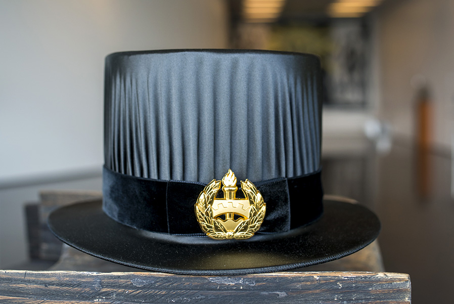 Tohtorinhattu jossa Tampereen yliopiston embleemi