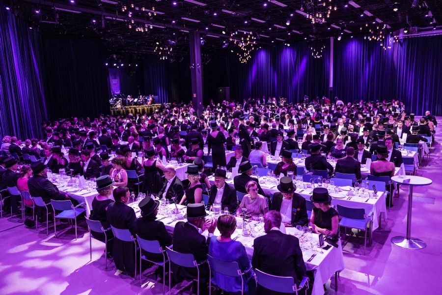 Promovoituja tohtoreita ja muita vieraita illallispöydissä