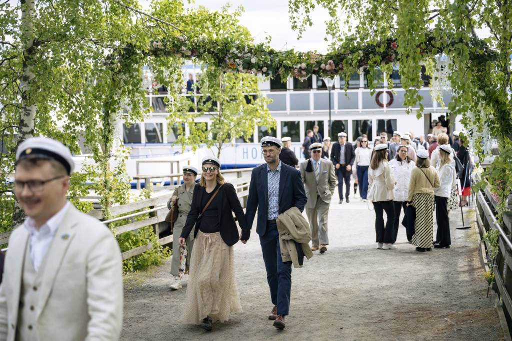People with student caps on are coming off a ship
