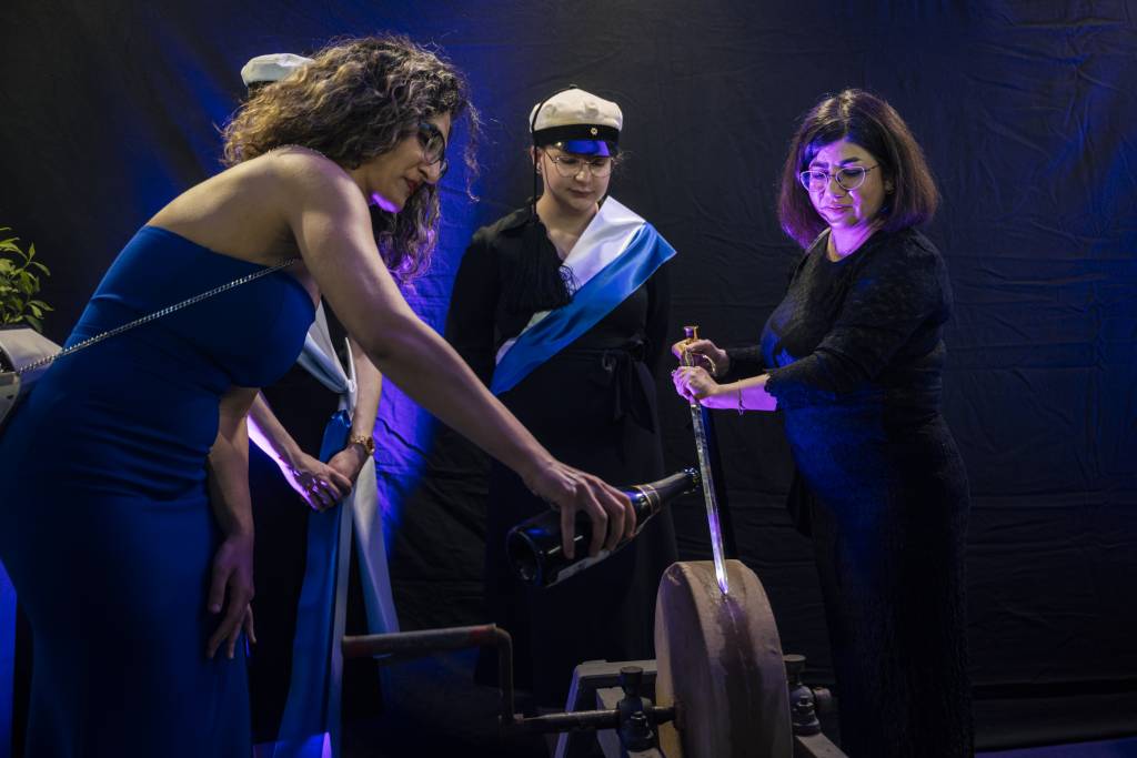 Two people are whetting a sword