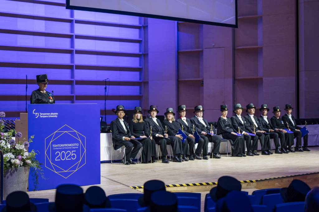 Representative of honorary doctors is speaking and other honorary doctors are sitting in a line