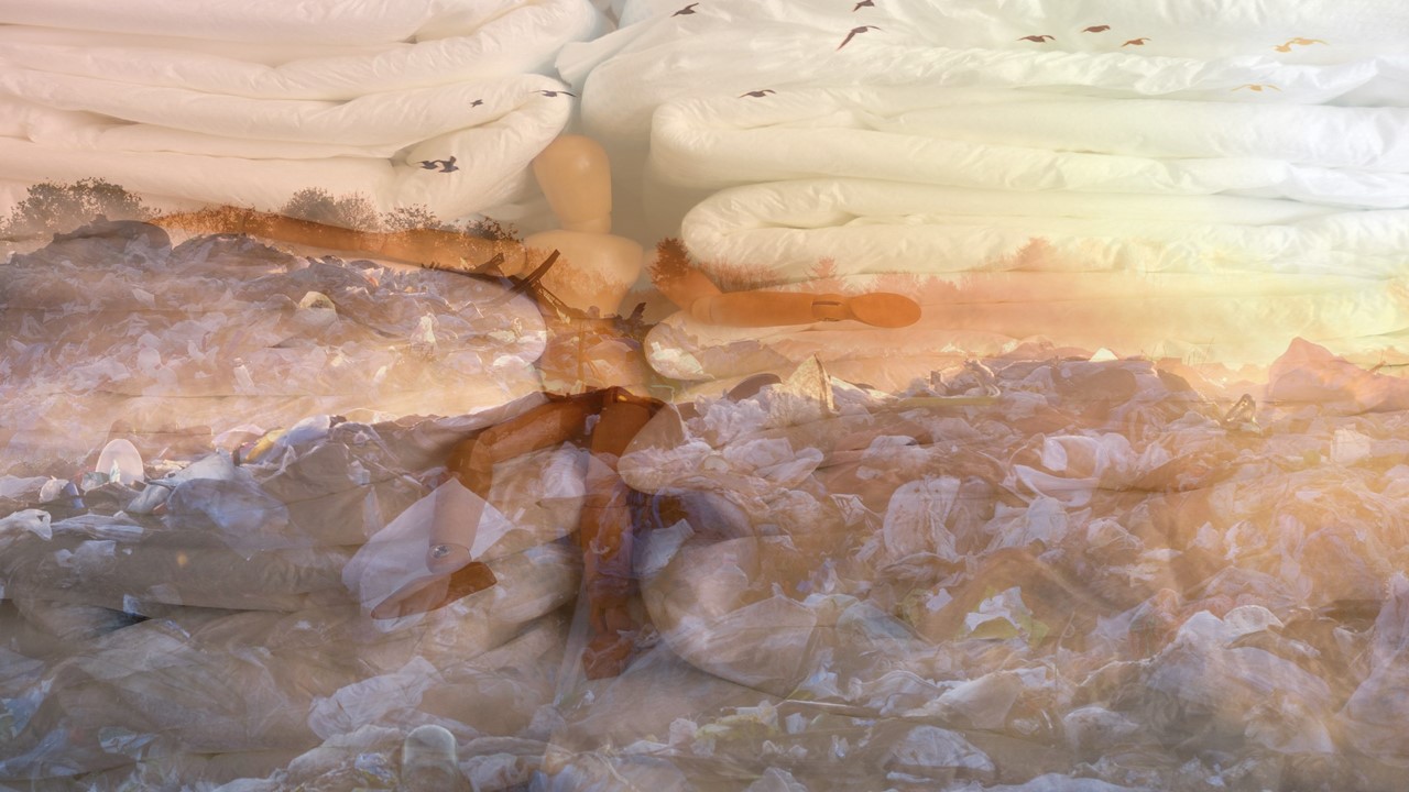 picture of a wooden doll in between stacks of incontinence pads merged with a picture of a landfill in sunrise