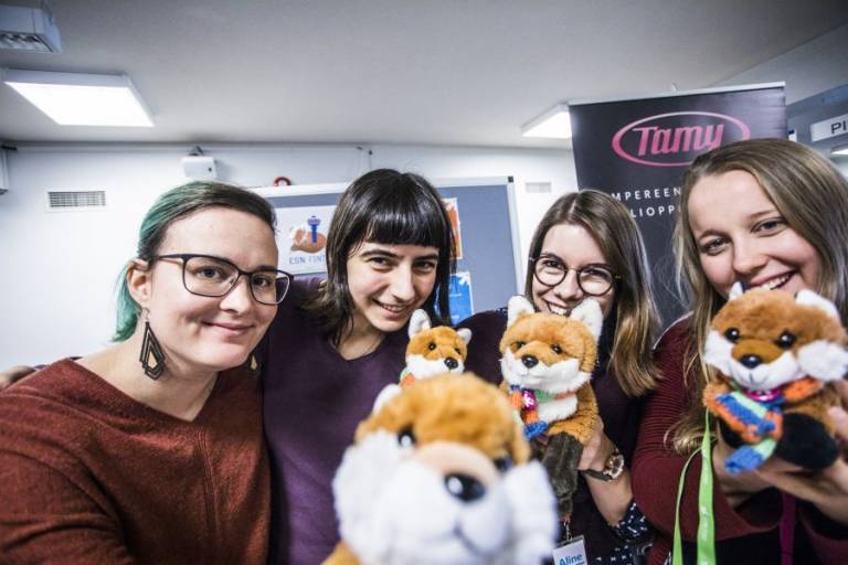 Four students with stuffed animals in their hands